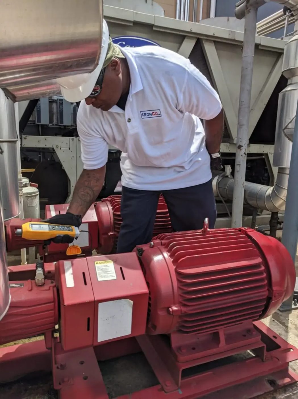 Ronco technician testing an industrial electric motor with a handheld instrument