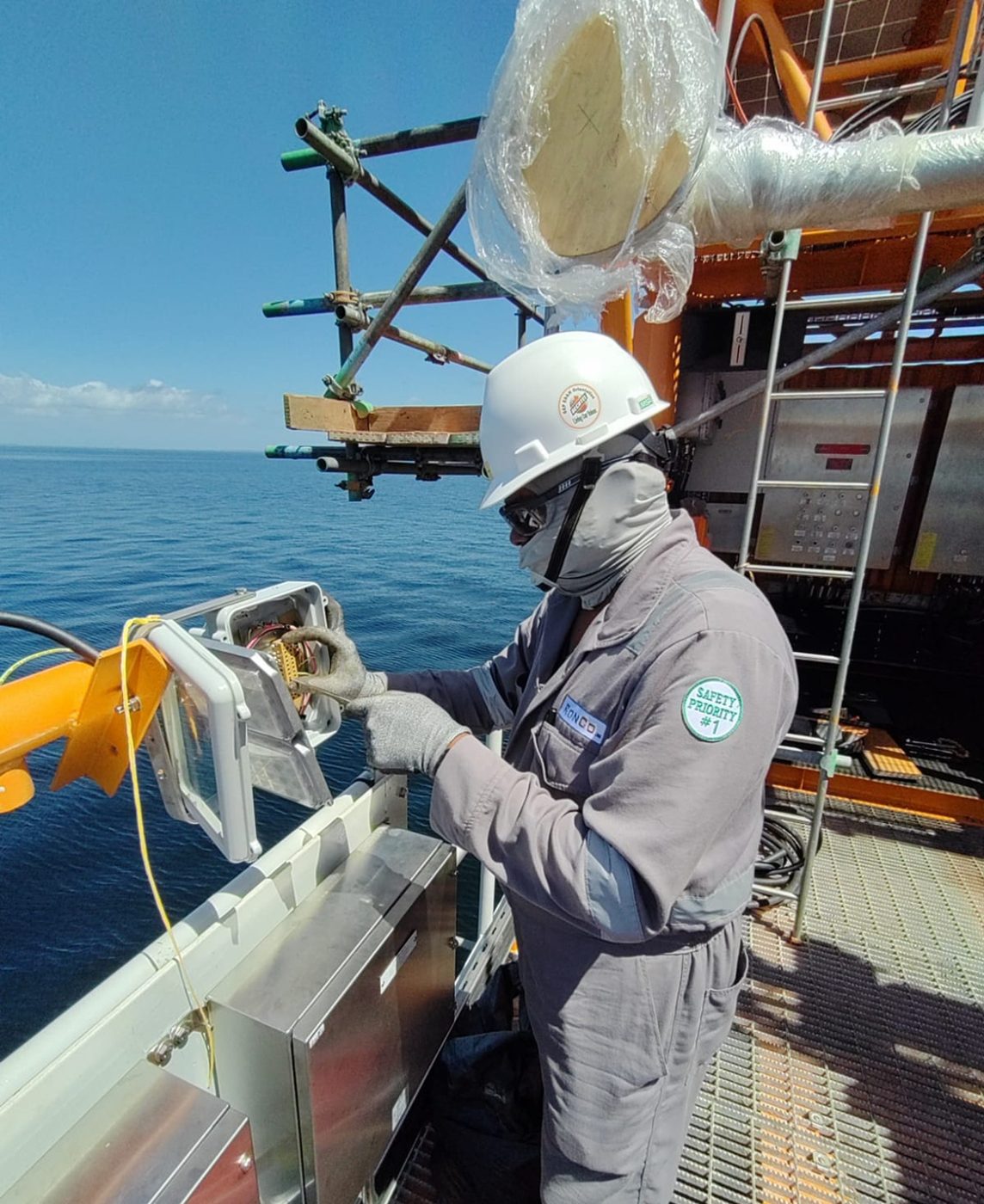 Ronco technician servicing an offshore instrument junction box on a platform deck